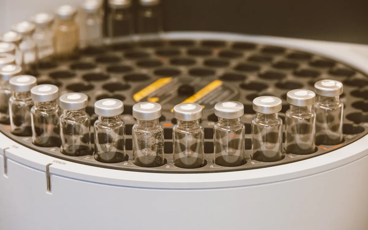 Row of clear glass vials with crimp caps